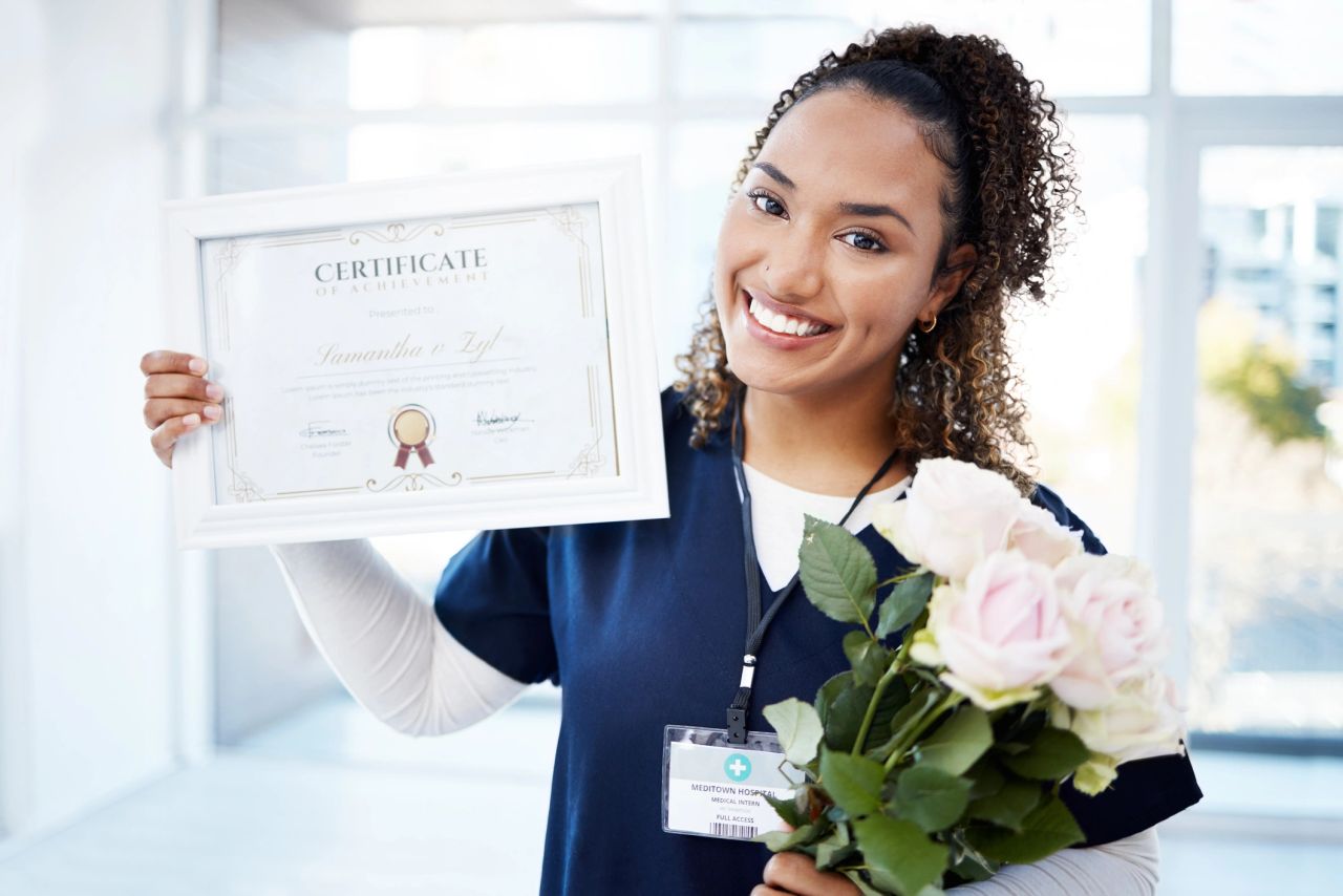 Nursing graduate proudly holding her certificate